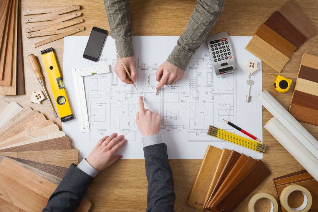 Customer businessman and construction engineer working together on a building project, desktop top view
