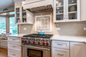 White Kitchen Counter and Cabinets with Designed Tile Backsplash