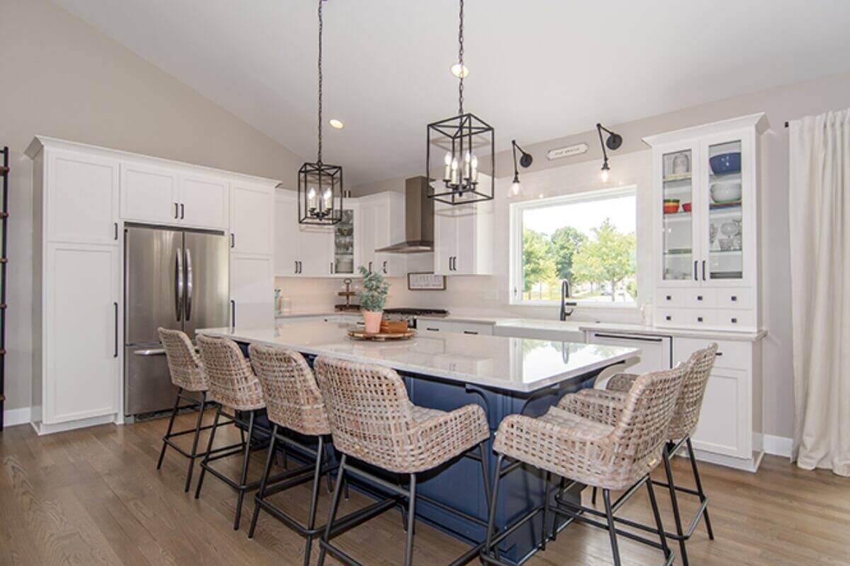 a large kitchen with a center island and chairs