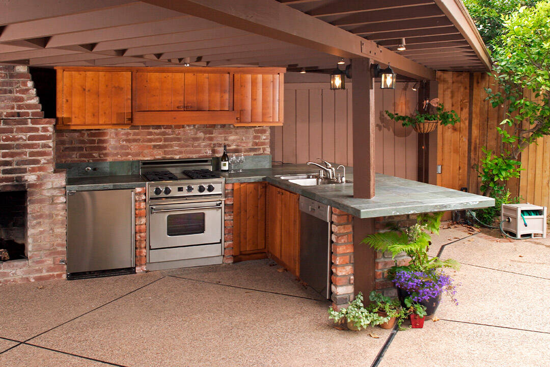 an outdoor kitchen with a stove and sink